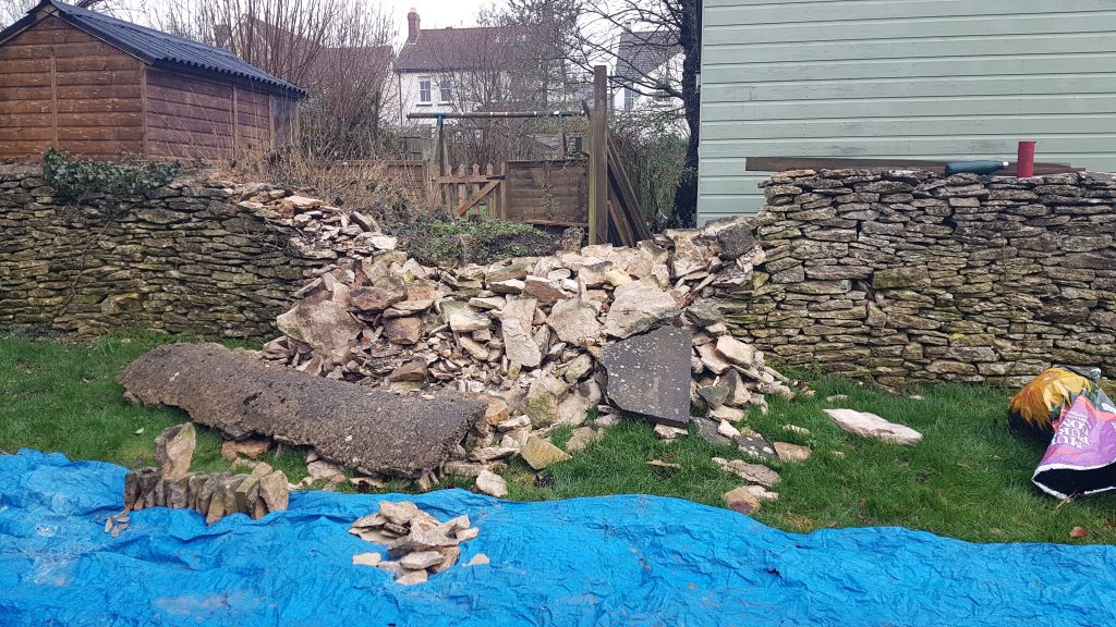 Repair of a dry stone garden boundary wall in Minchinhampton, Stroud, Cotswolds.