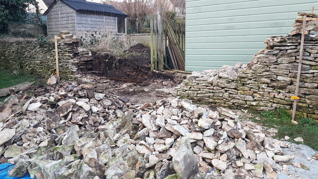 Repair of a dry stone garden boundary wall in Minchinhampton, Stroud, Cotswolds.