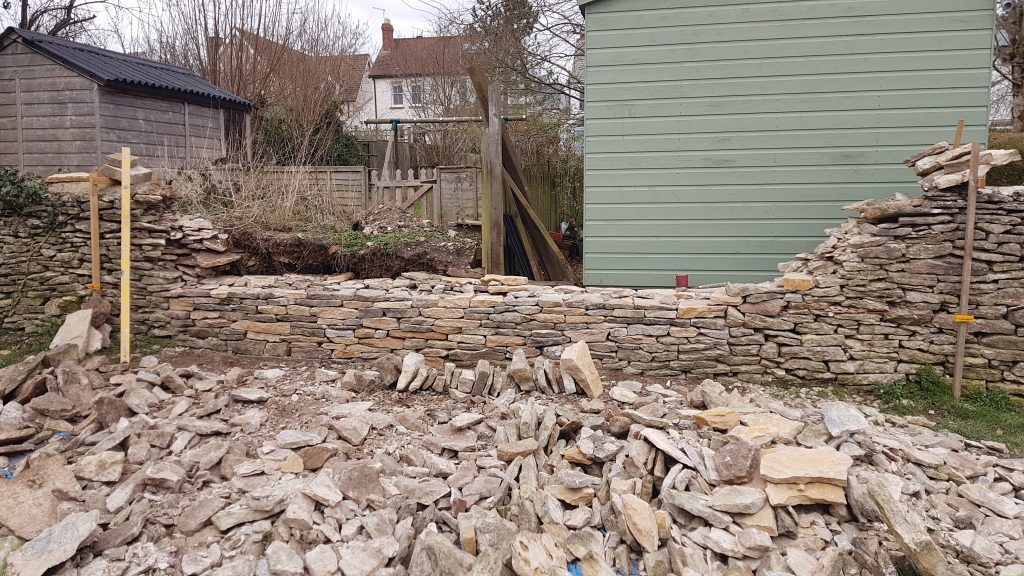 Repair of a dry stone garden boundary wall in Minchinhampton, Stroud, Cotswolds.
