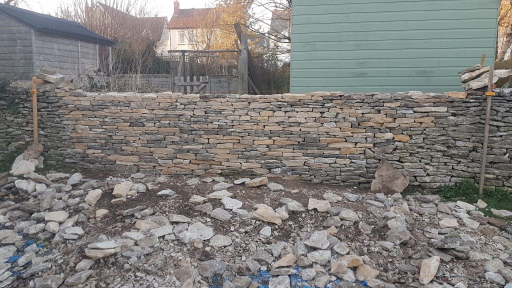 Repair of a dry stone garden boundary wall in Minchinhampton, Stroud, Cotswolds.