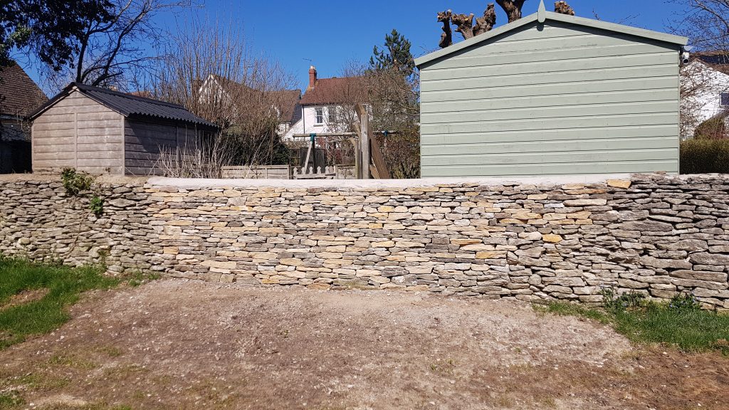 Repair of a dry stone garden boundary wall in Minchinhampton, Stroud, Cotswolds.