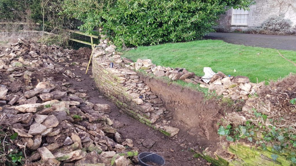 Repair and rebuild of a dry stone retaining wall and ha-ha in Kemble, Cirencester, Cotswolds
