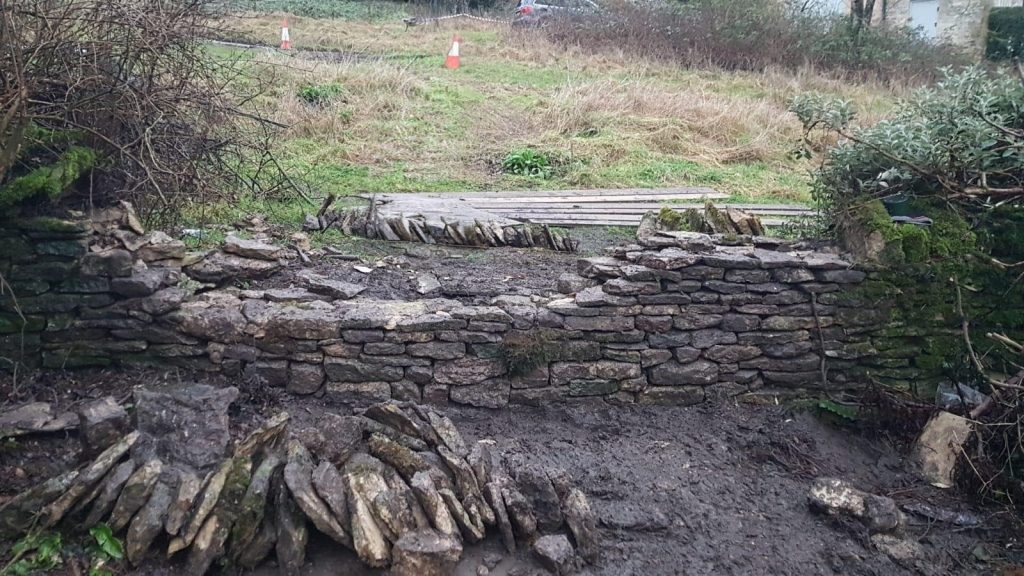 A partially finished rebuild of a dry stone wall in Chalford, Stroud, Cotswolds.