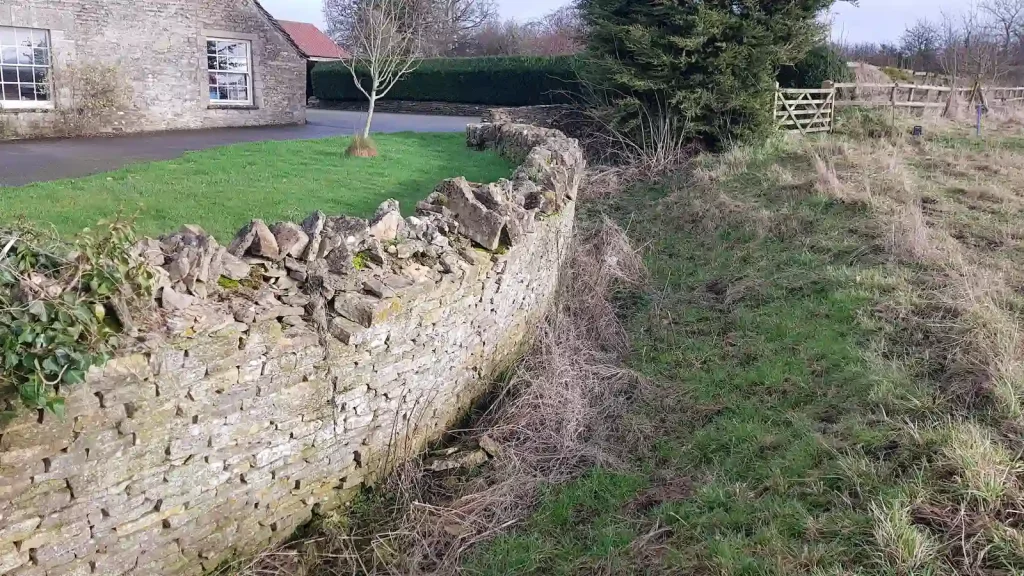 Damaged dry stone ha-ha in Kemble near Cirencester prior to restoration work.