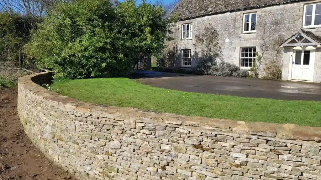 Dry stone walling in progress restoring damaged ha-ha in Kemble near Cirencester.