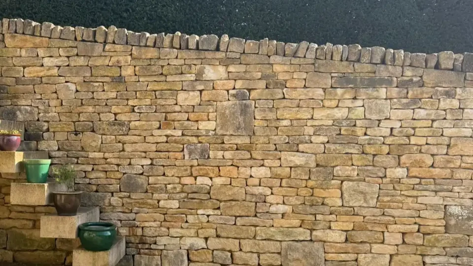 Completed dry stone walling on a concrete retaining wall in Oakridge Lynch near Stroud.