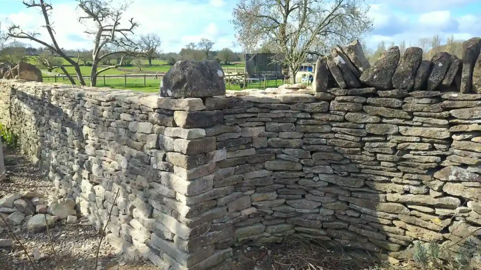 Dry stone wall repair completed for garden boundary wall in Didmarton near Tetbury before cock and hen coping.