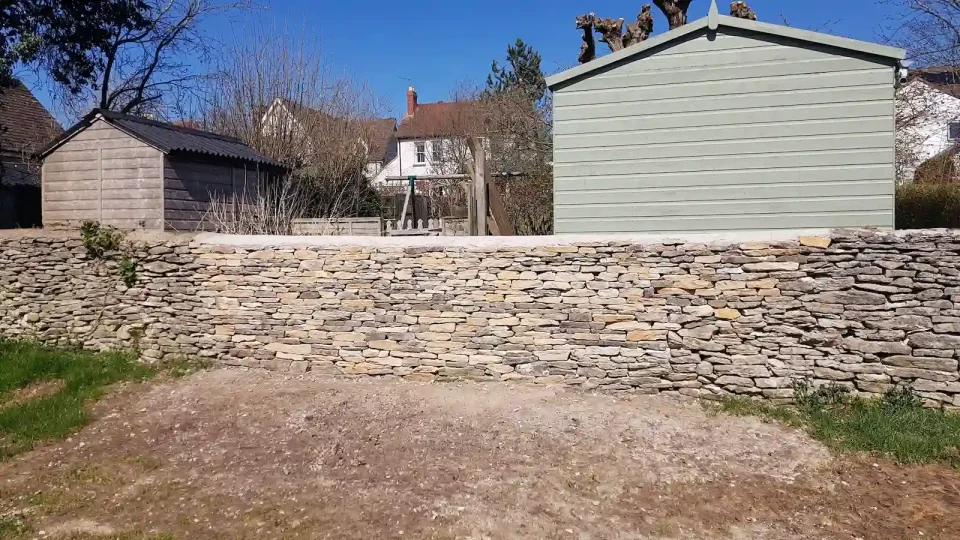 Completed dry stone wall restoration of retaining garden boundary wall in Minchinhampton near Stroud.